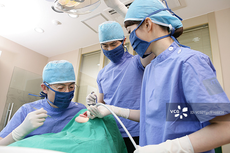 牙医和牙科助手在牙科诊所为病人进行手术图片素材