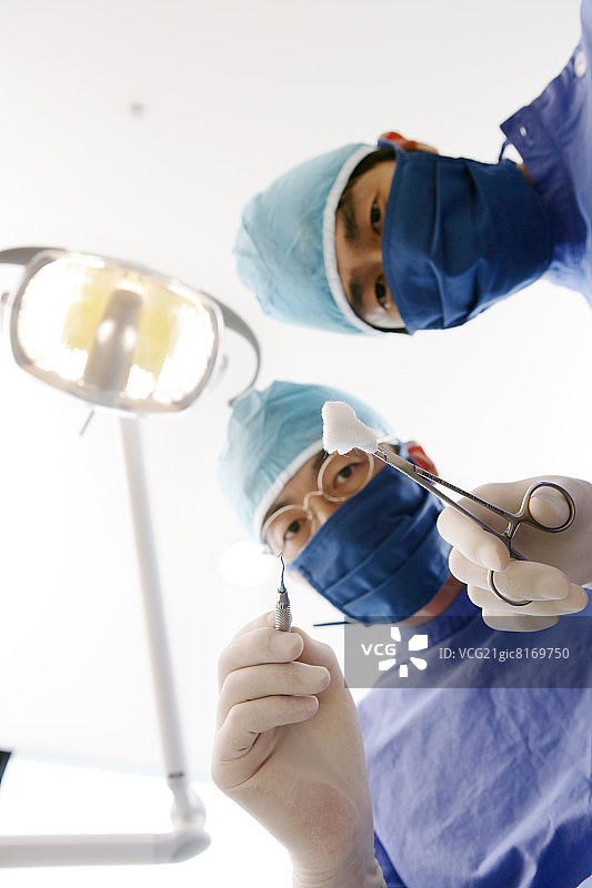 牙医和牙科助手拿着牙科设备图片素材