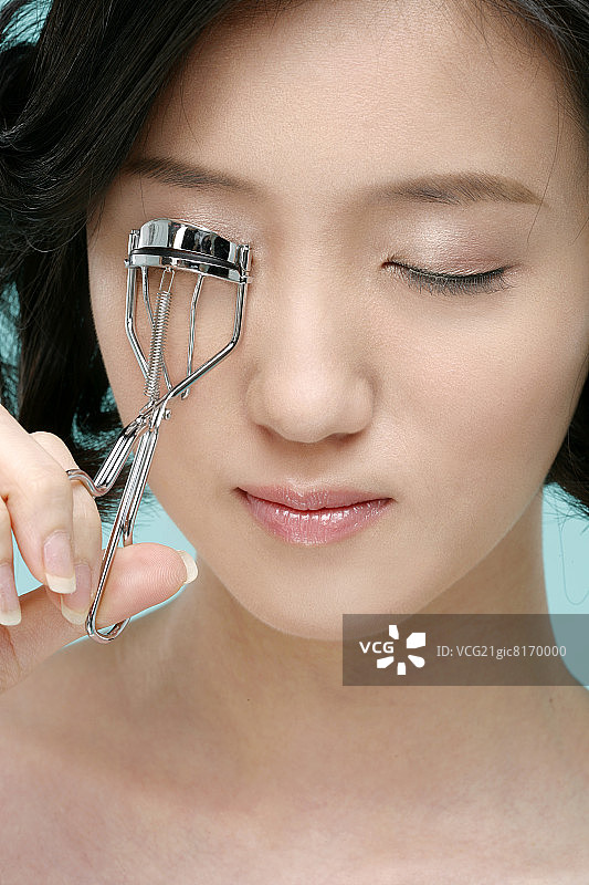 女人使用睫毛夹，特写图片素材