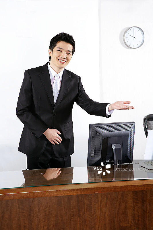 在办公室指导工作的微笑男商人肖像图片素材