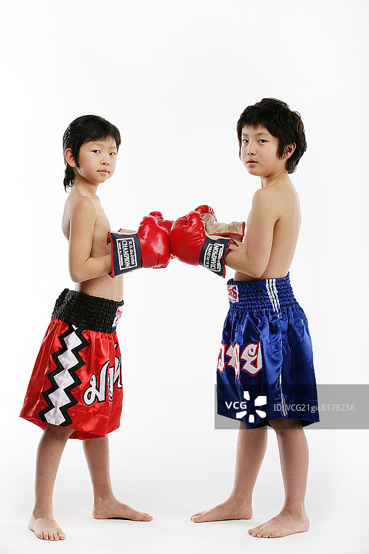 两个男孩（12-13岁）戴着拳击手套的特写肖像图片素材
