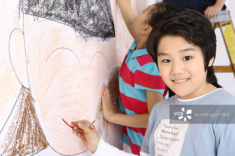 男孩在墙上画脸图片素材