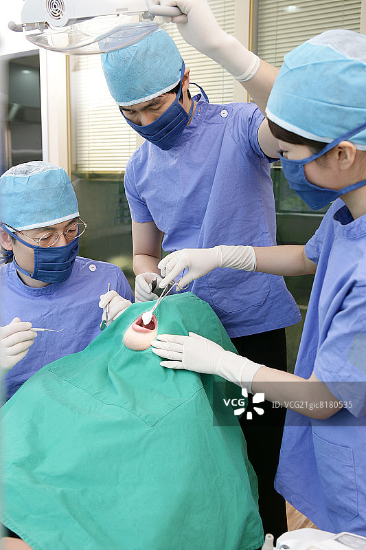 牙医和牙科助手在牙科诊所为病人进行手术图片素材