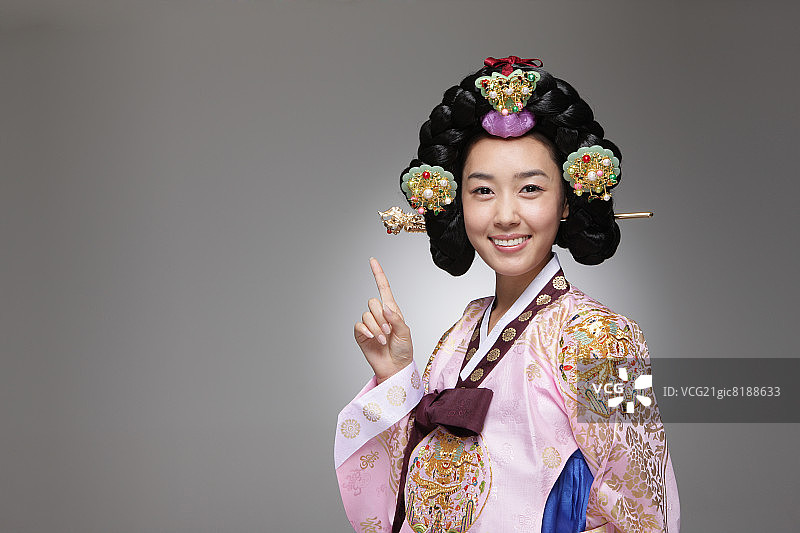穿着传统韩服，伸出一根手指的女人图片素材