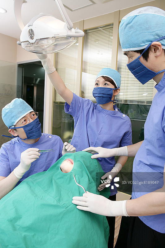牙医和牙科助手在牙科诊所为病人进行手术图片素材