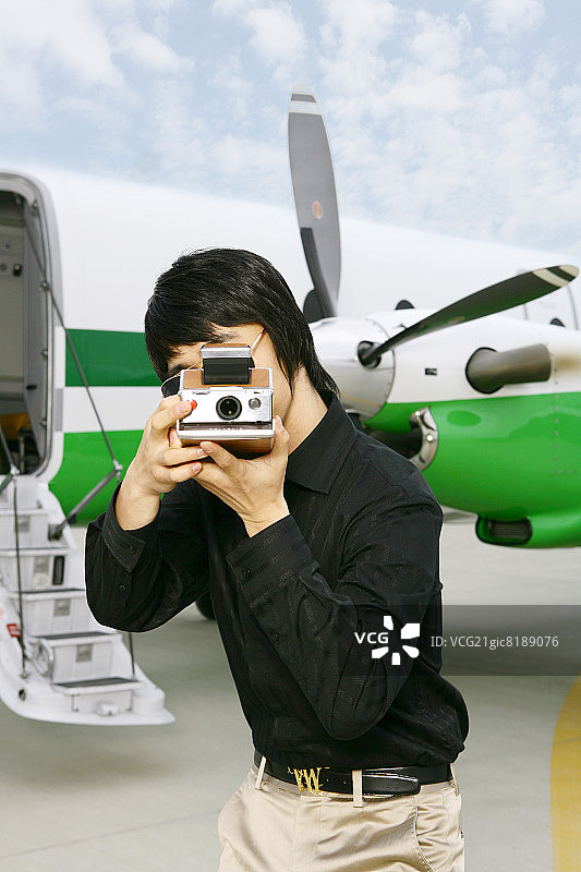 男子在机场拍摄宝丽来照片图片素材