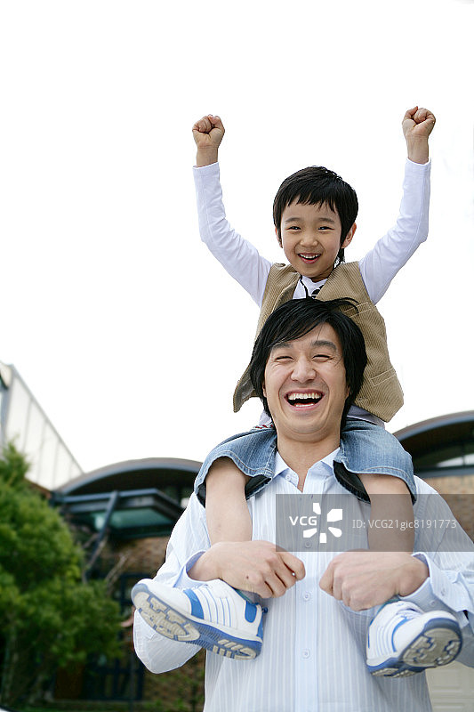 父亲扛着儿子（6-7岁），微笑的肖像图片素材