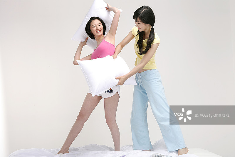 女人们在玩枕头大战，面带微笑图片素材