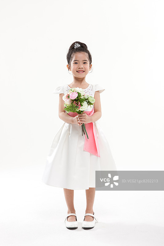 女儿穿着粉色丝带的裙子，手捧花束图片素材