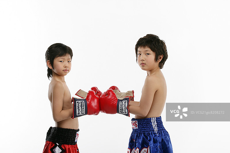 两个男孩（12-13岁）戴着拳击手套的特写肖像图片素材
