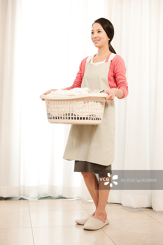 手提洗衣篮的家庭主妇图片素材