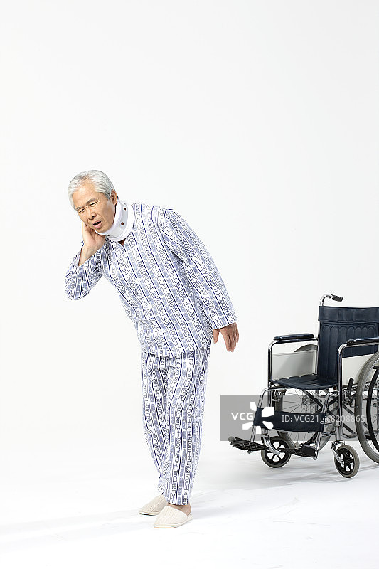戴着颈托痛苦行走的老年男人图片素材