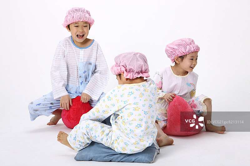 戴着睡帽和穿着睡衣玩耍的儿童图片素材