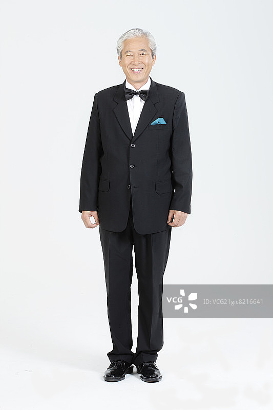 身穿燕尾服的微笑老年男子图片素材