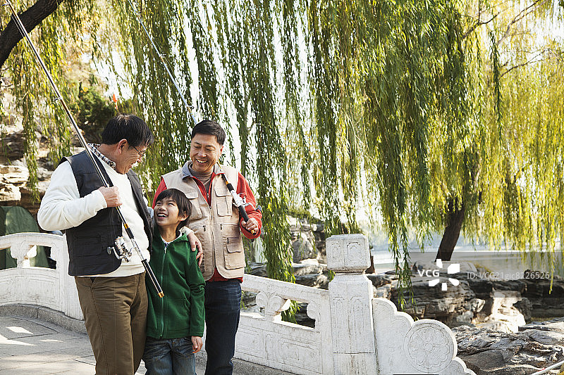 多代男人带着渔具在湖边散步图片素材