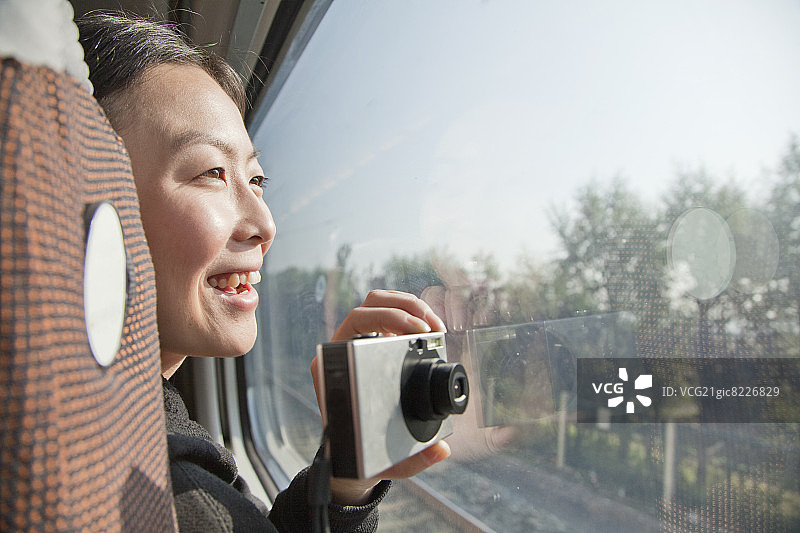 年轻女子在火车窗外拍照图片素材