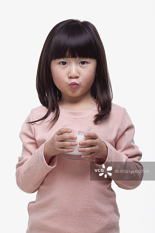 喝牛奶做鬼脸的少女肖像图片素材