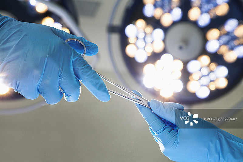 戴手套的手传递手术剪刀特写，手术室，医院图片素材