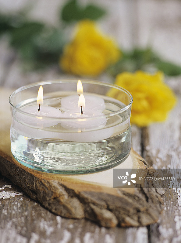 木制拼盘上的三根漂浮蜡烛图片素材