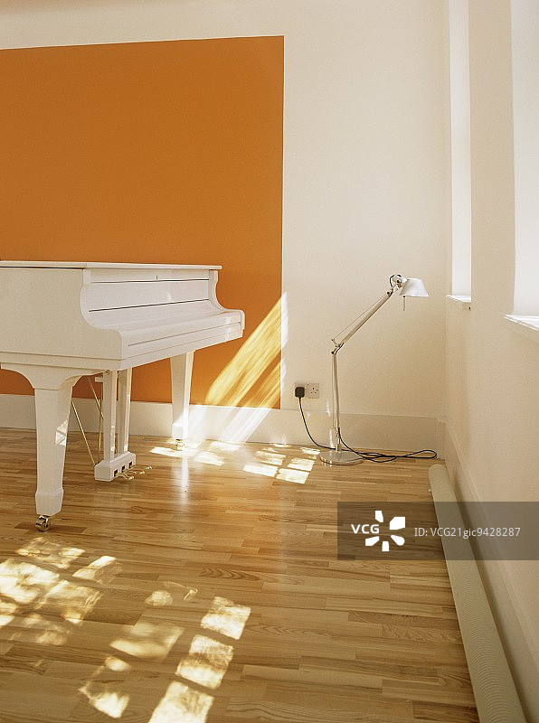 现代白色和橙色简约音乐室，三角钢琴，木地板，灯图片素材