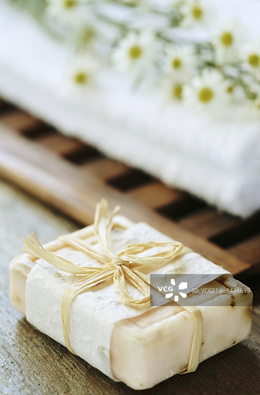 一块肥皂、毛巾和白色翠菊图片素材