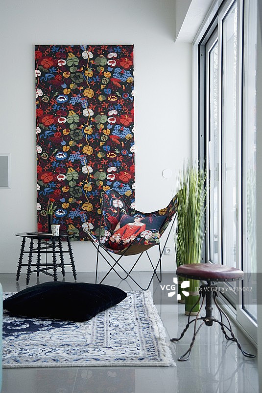 房间一角，光线充足，配有经典蝴蝶椅和相配的画作图片素材