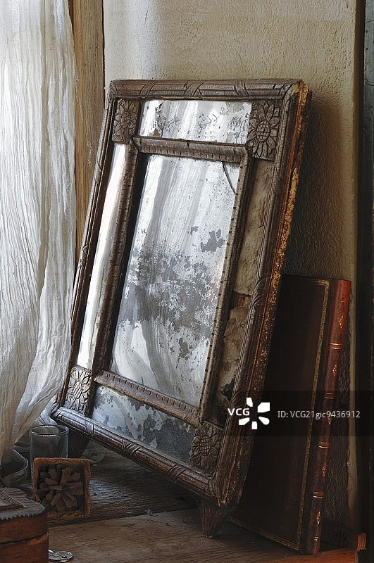 雕刻木制相框和金色皮革古籍靠墙摆放图片素材