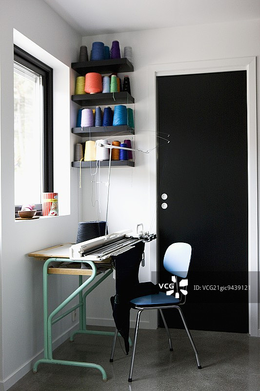 工作区：桌上的针织机与彩色纱线架图片素材