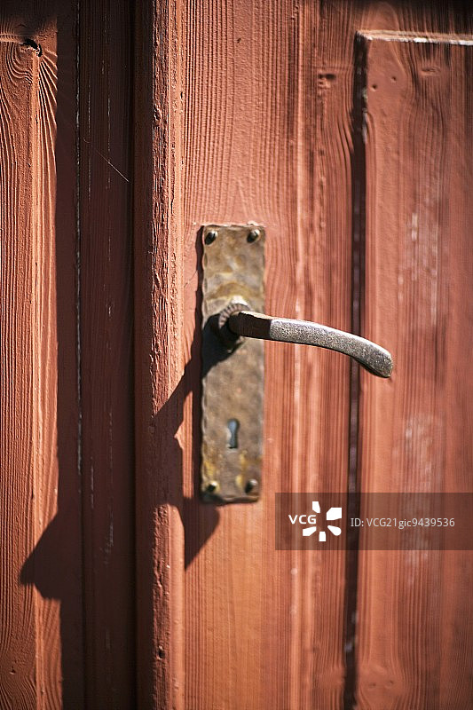带手工金属把手的红色老木门图片素材