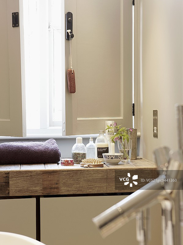 乡村木制盥洗台上半开窗户前的各种洗漱用品图片素材