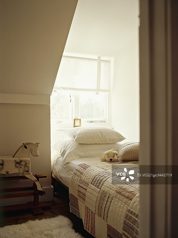 阁楼房间窗台壁龛上的拼布被子图片素材