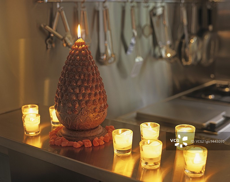 厨房台面上点燃的玻璃茶灯座和锥形蜡烛图片素材