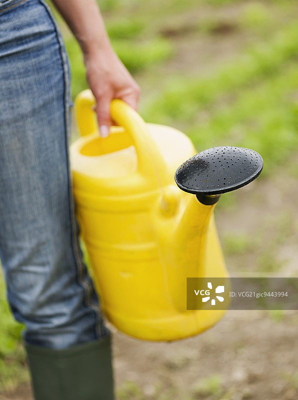 女人在花园里拿着喷壶图片素材