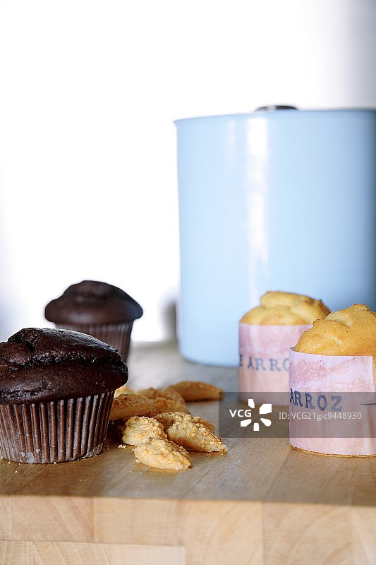 巧克力玛芬和西班牙纸杯蛋糕，浅蓝色搪瓷锅背景图片素材