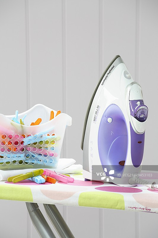 熨衣板上的熨斗和衣夹图片素材