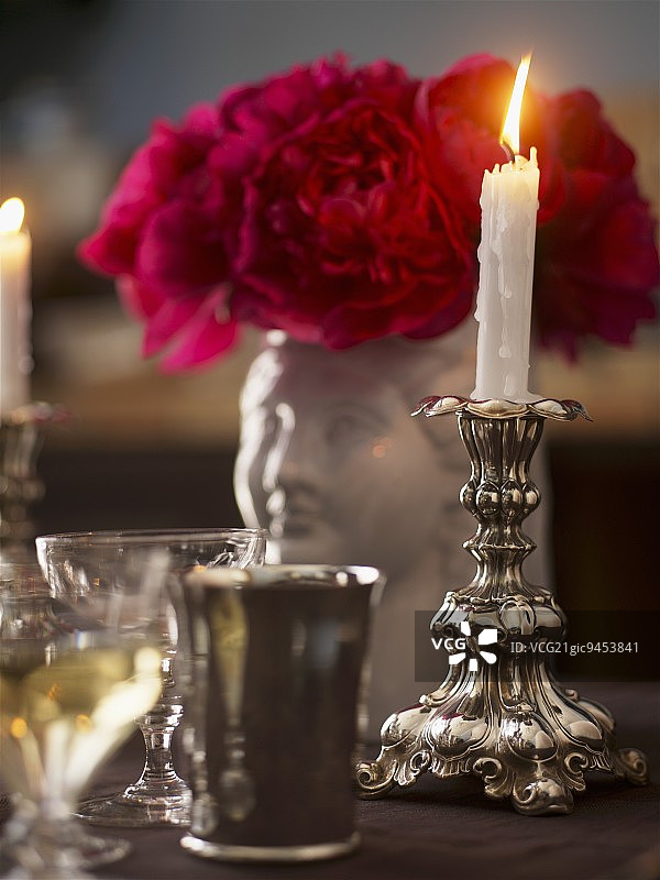 带玫瑰和玻璃杯的烛台上的蜡烛图片素材