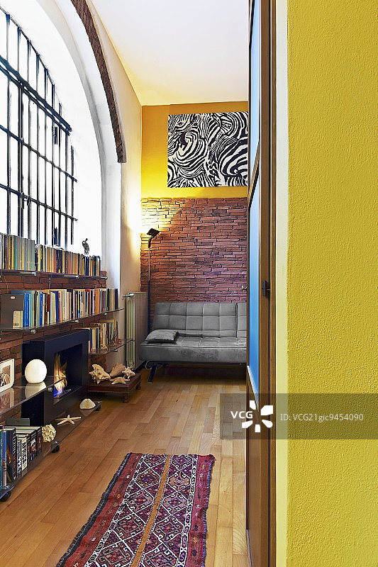 阁楼式室内一角，透过敞开的门看到的景色：民族风地毯，拼花地板，工业风窗户下的半高搁架图片素材