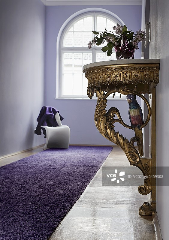 洛可可风格的控制台桌子，位于淡紫色时期走廊中；白色潘顿椅子在拱形窗户的背景下图片素材