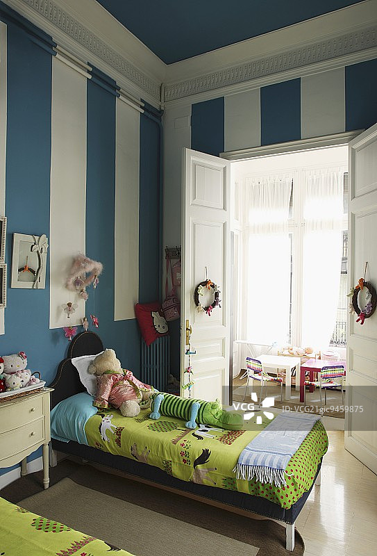 儿童卧室中带白色条纹的蓝色墙面和双人床图片素材