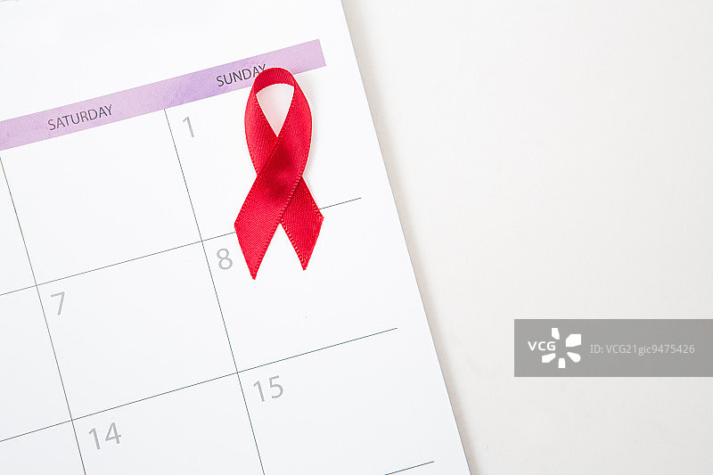 白色日历上标志世界艾滋病日的红色宣传丝带图片素材