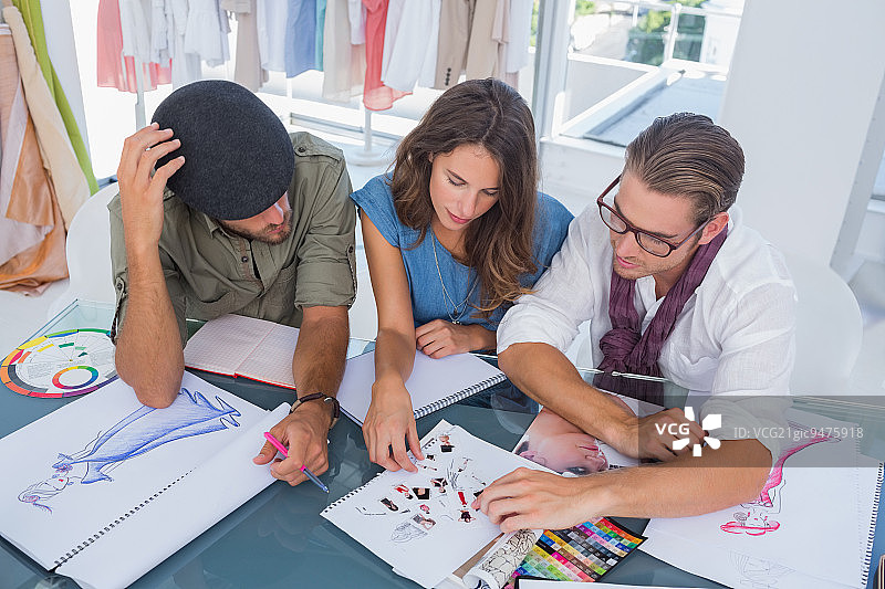 三位时装设计师在明亮的办公室里一起工作图片素材