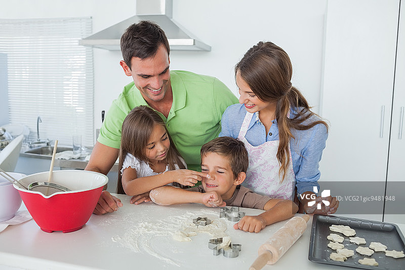 姐姐给弟弟鼻子抹面粉与父母烘焙图片素材