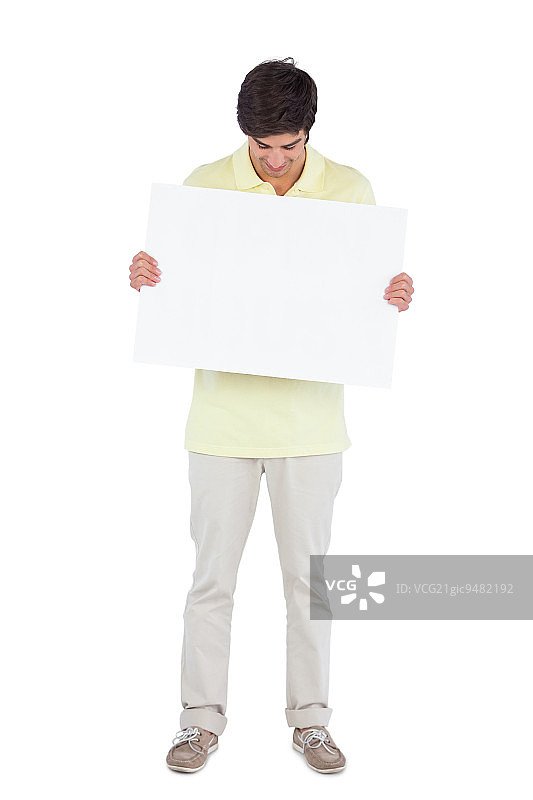 年轻男人看着白色背景上的空白面板图片素材