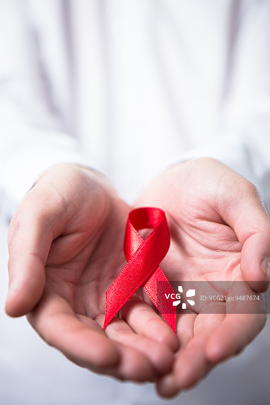 男人穿着衬衫手持红色艾滋病丝带图片素材