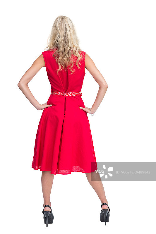 穿着红色连衣裙的金发美女在白色背景上摆姿势的背影图片素材