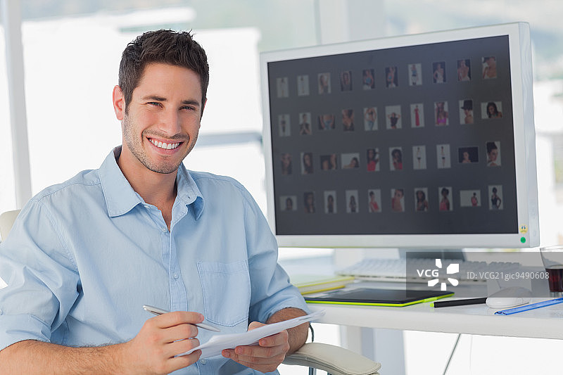 在他的办公室里拿着文件的英俊照片编辑图片素材