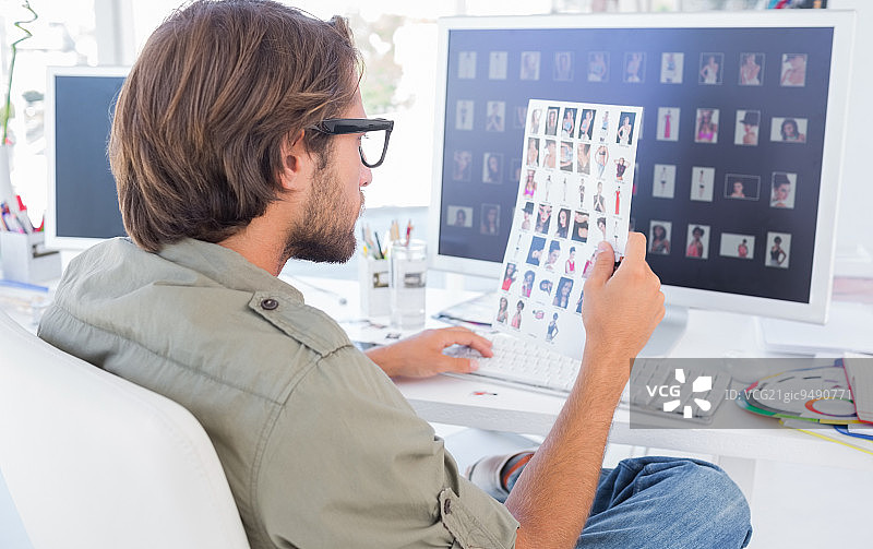 照片编辑在办公桌前检查样片图片素材