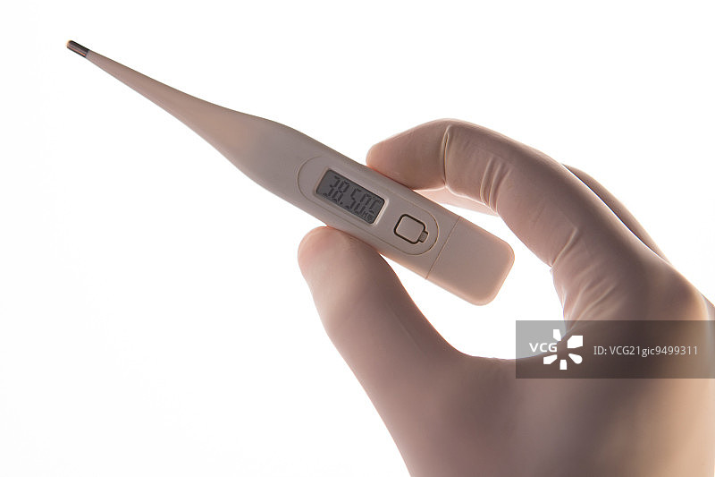 戴手套的手在白色背景上拿着数字温度计图片素材