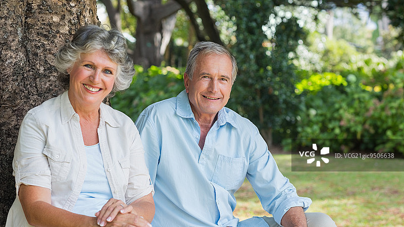 在公园里微笑看着镜头的快乐中年夫妇图片素材