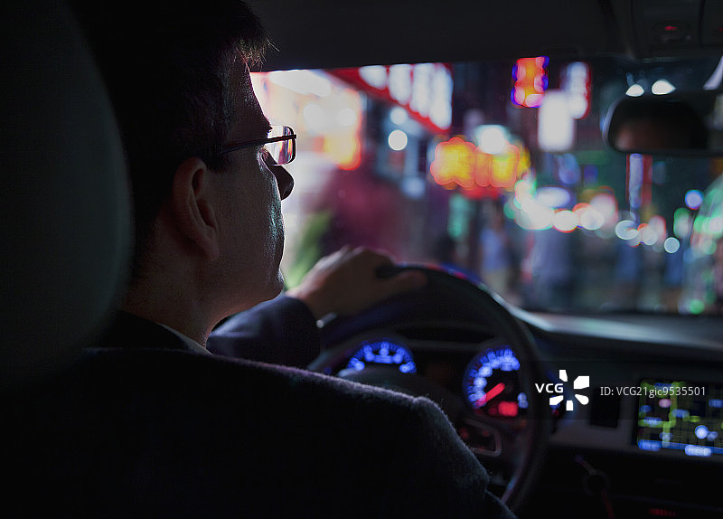 肩膀视角下商人夜间驾车城市灯光图片素材
